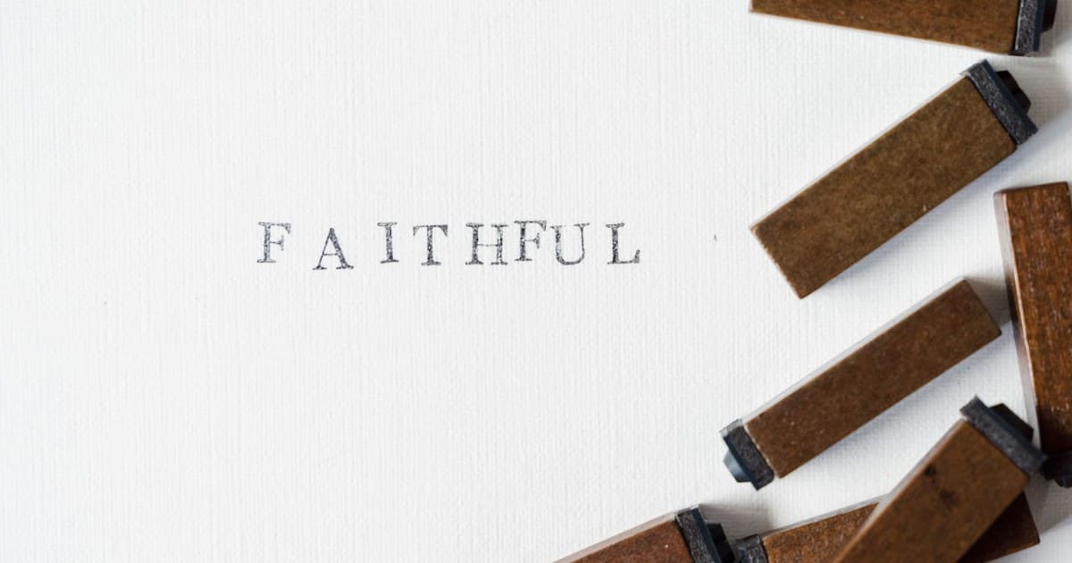 흰 종이에 'FAITHFUL'을 찍어 놓은 활자와 나무 활자 조각들